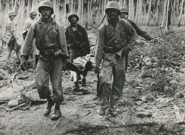 Four US Marines carry an injured compatriot