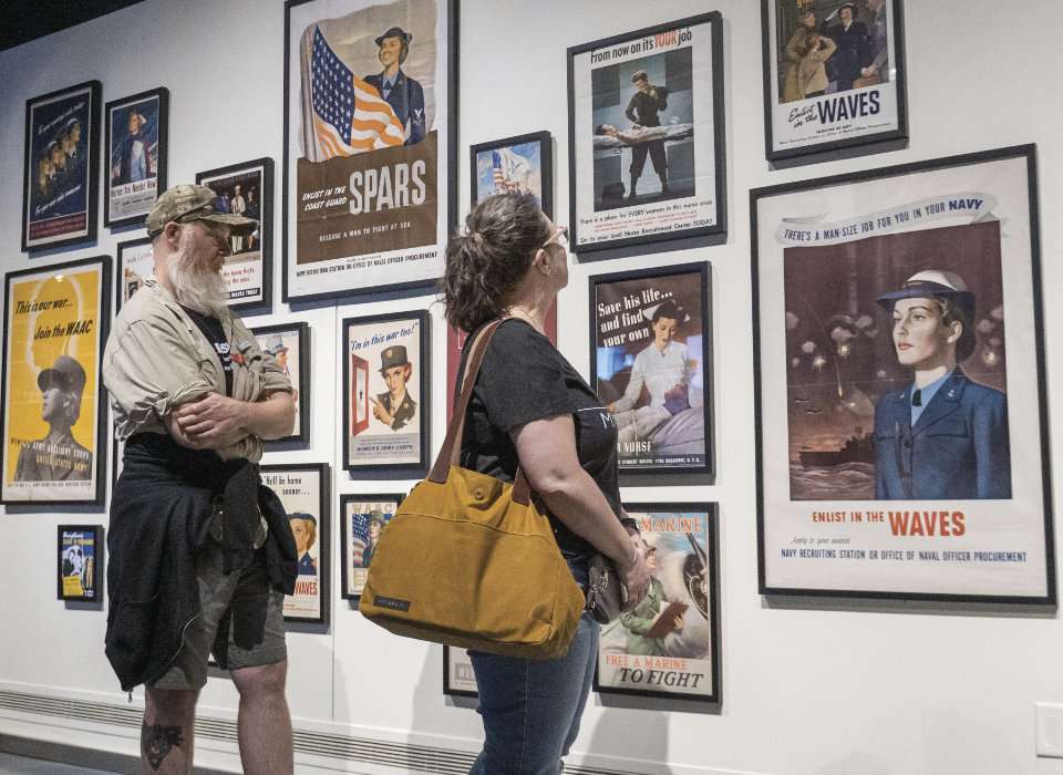 A couple viewing the Our War Too exhibit at the National WWII Museum
